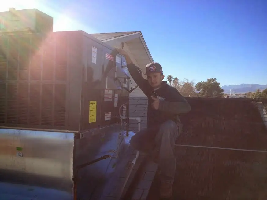 HVAC technician performing Air Duct Repair on a rooftop unit in Chaska